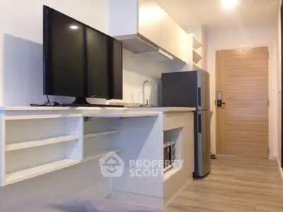 Modern kitchen with sleek appliances and open shelving in a stylish apartment.