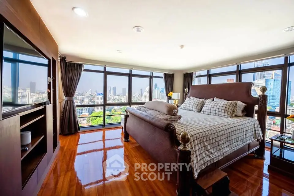 Luxurious bedroom with panoramic city view and elegant wooden flooring.