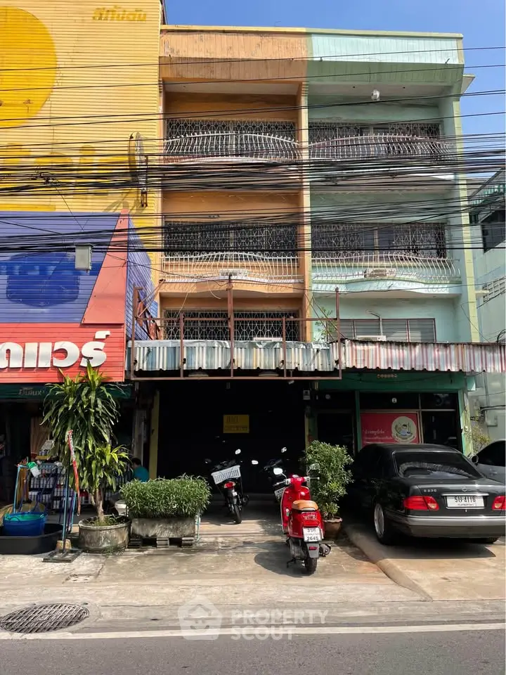 Charming urban building with vibrant facade and street-level parking, ideal for commercial or residential use.