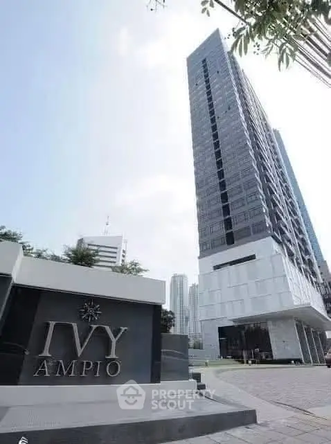 Modern high-rise building with sleek architecture and prominent signage in urban setting.