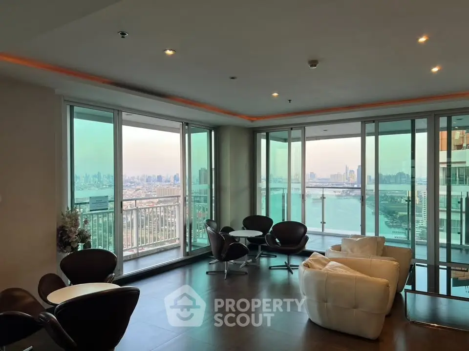 Luxurious high-rise living room with stunning city and river views, modern furniture, and expansive windows.
