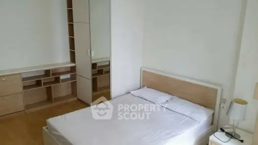 Spacious bedroom with modern furniture and ample storage space.