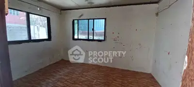 Spacious empty room with large windows and wooden flooring, ideal for customization.