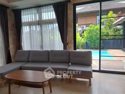 Spacious living room with pool view and modern furniture in luxury home