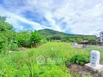 Scenic land plot with lush greenery and mountain backdrop, ideal for development.