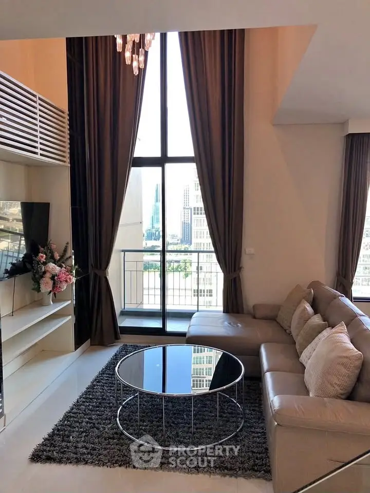 Luxurious living room with high ceilings, large windows, and elegant decor in a modern apartment.