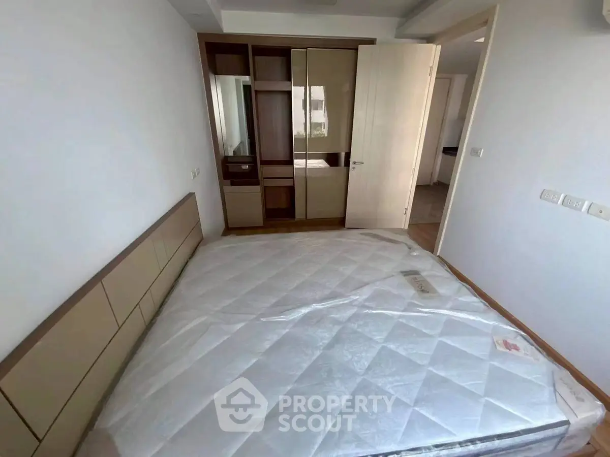 Modern bedroom with built-in wardrobe and large bed in a bright apartment.