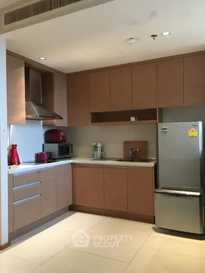 Modern kitchen with sleek cabinetry and stainless steel appliances in a cozy apartment.