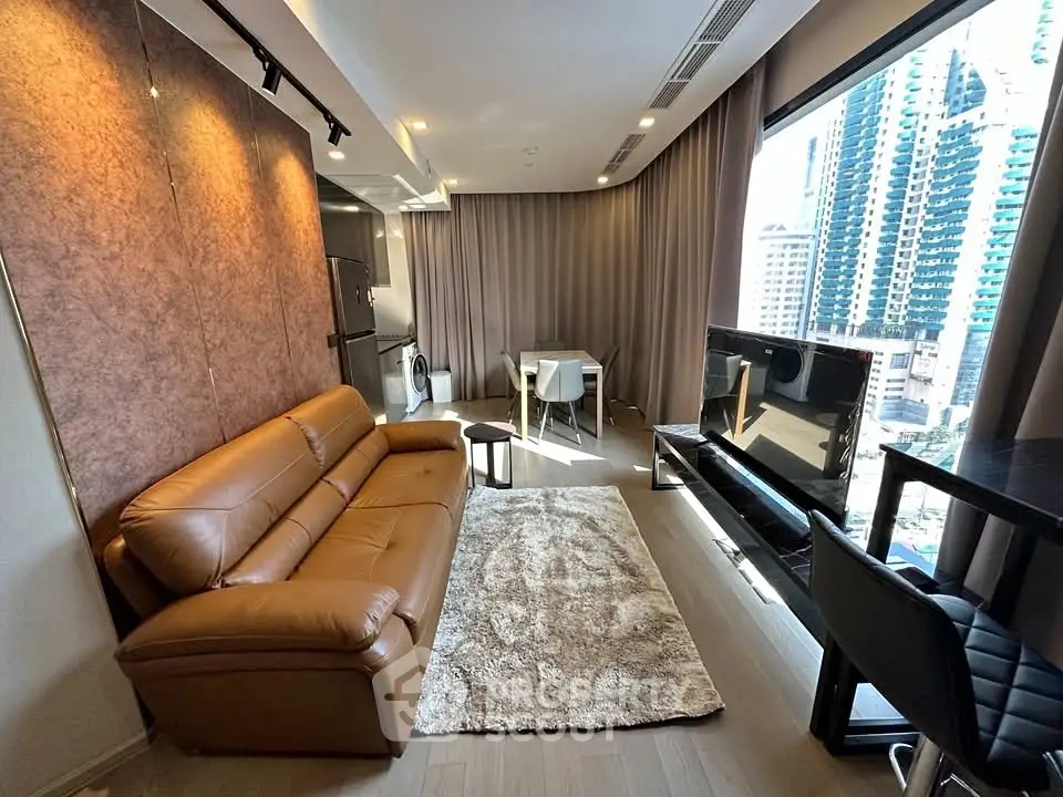 Modern living room with leather sofa and city view, featuring sleek design and abundant natural light.
