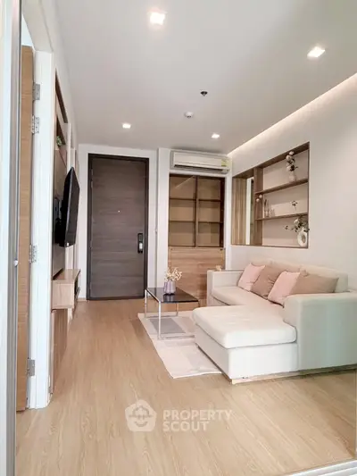 Modern living room with cozy sofa, wooden flooring, and built-in shelves in a stylish apartment.