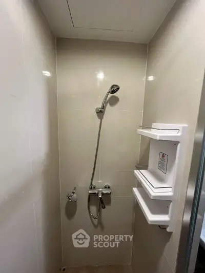 Modern bathroom shower area with sleek fixtures and built-in shelves.