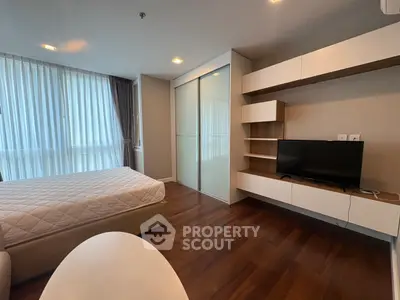 Modern bedroom with sleek furniture and large window for natural light