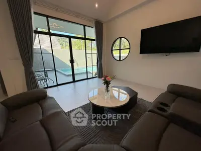 Modern living room with pool view, sleek furniture, and stylish decor