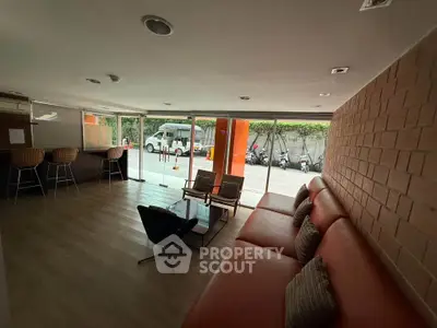 Modern lounge area with stylish seating and large windows overlooking parking area