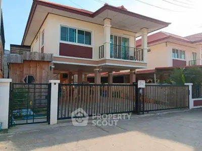 Charming two-story house with gated entrance and balcony in a serene neighborhood.