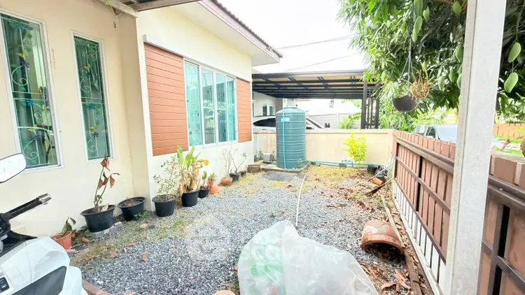 Charming garden area with potted plants and gravel path in cozy residential property.