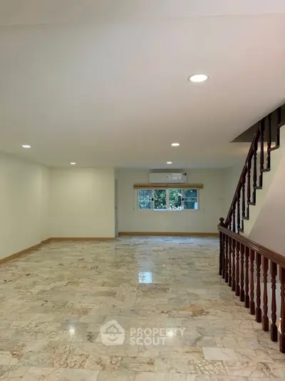 Spacious interior with marble flooring and staircase, ideal for modern living.