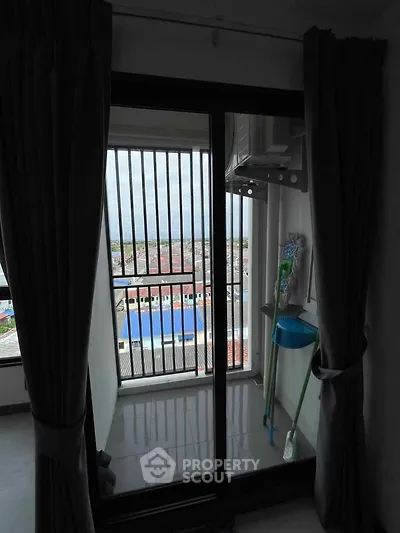 Compact balcony with city view and cleaning tools, ideal for urban living.