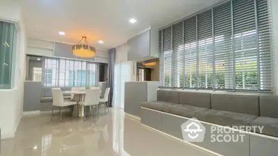 Modern dining area with elegant chandelier and large windows in a stylish home