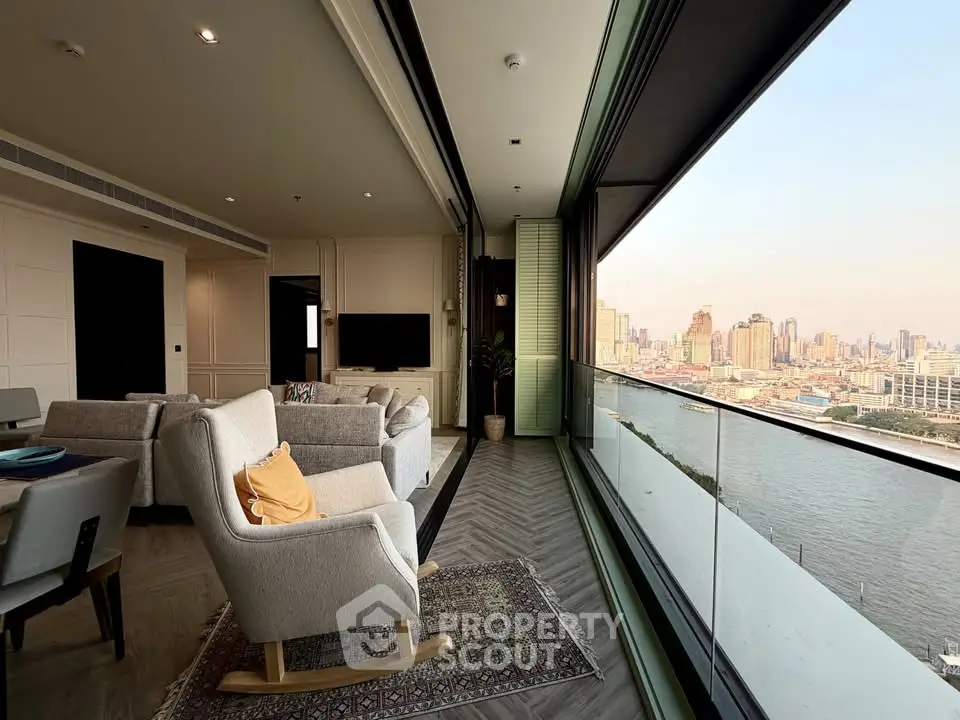 Luxurious living room with stunning river view and spacious balcony in modern high-rise apartment.