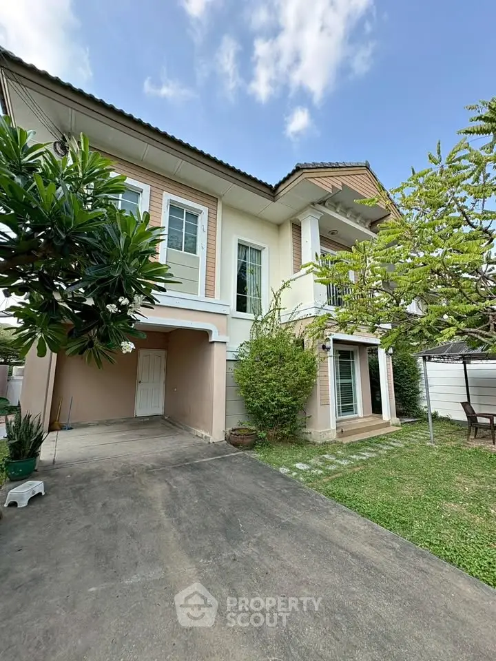 Charming two-story house with lush garden and spacious driveway, perfect for family living.