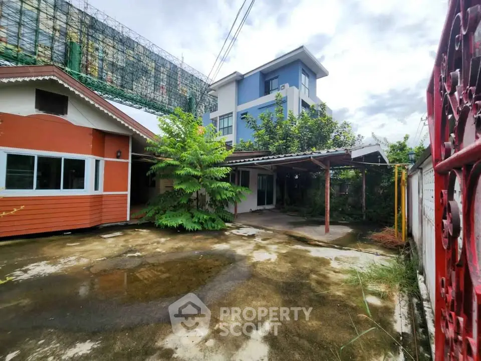 Charming two-story house with spacious driveway and lush greenery, perfect for family living.