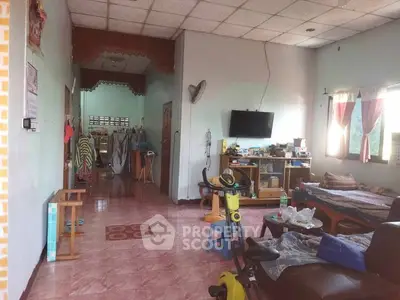 Spacious living room with exercise equipment and natural light, ideal for family gatherings.