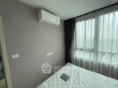 Modern bedroom with air conditioning and large window offering city views.