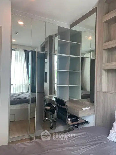 Modern bedroom with mirrored wardrobe and sleek study area