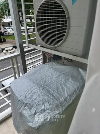 Compact balcony with air conditioning unit and covered outdoor appliance