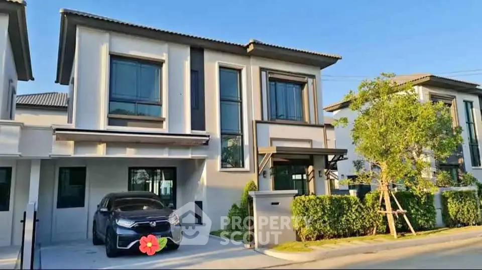 Modern two-story house with attached garage and landscaped front yard in a suburban neighborhood.