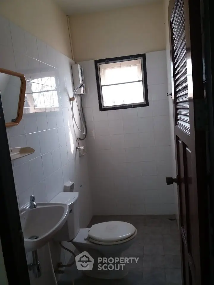 Compact bathroom with window and basic fixtures in a residential property.