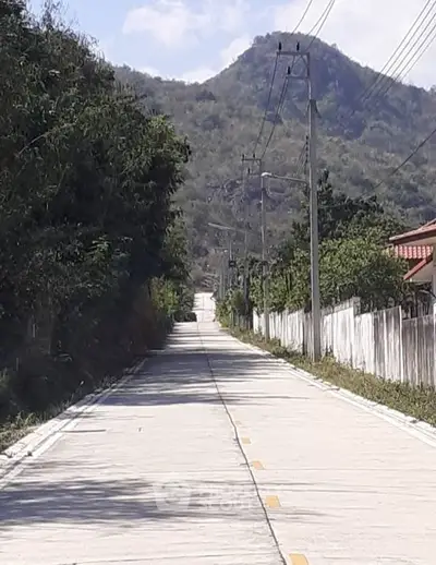 Scenic road with mountain view, ideal for serene residential development.