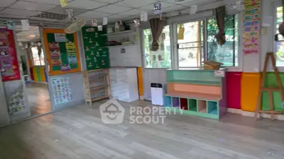 Bright and colorful classroom with educational posters and storage shelves.