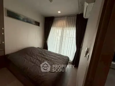 Cozy bedroom with large window and modern decor, perfect for relaxation.