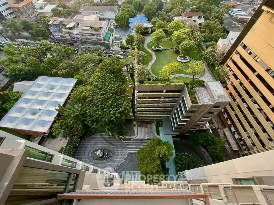 Stunning aerial view of modern urban residential complex with lush green gardens and cityscape.
