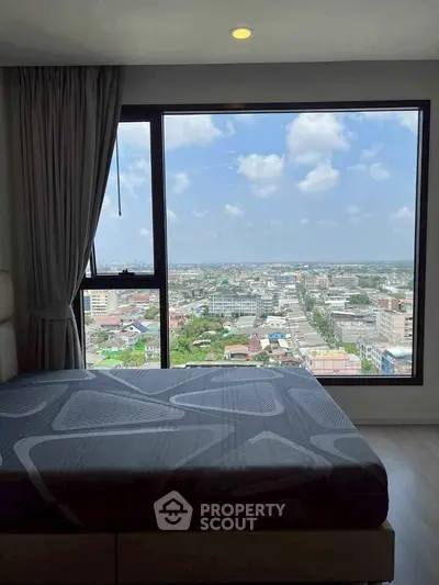 Stunning city view from a modern bedroom with large window and cozy bed.