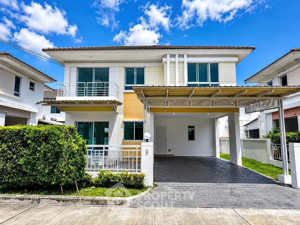 Modern two-story house with large windows and a spacious driveway in a suburban neighborhood.