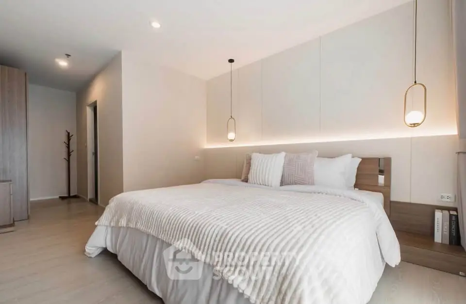 Luxurious modern bedroom with elegant lighting and cozy bedding in a stylish apartment.