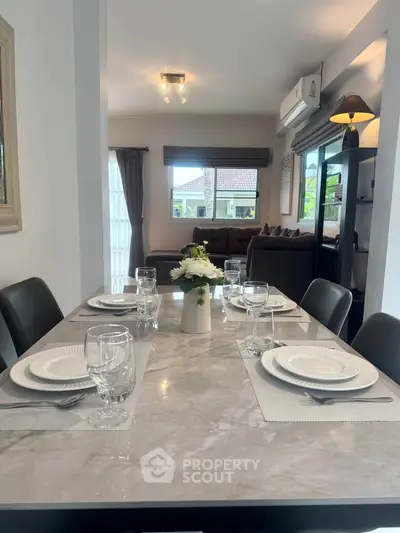 Elegant dining area with marble table and cozy living room view