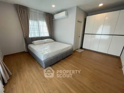 Spacious bedroom with modern design, featuring a large bed and ample closet space.