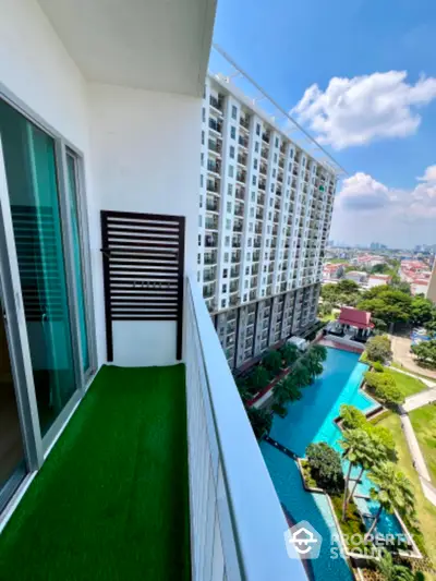 Stunning balcony view overlooking modern pool and lush greenery in urban high-rise.