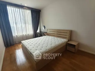 Spacious bedroom with natural light and modern furnishings in a stylish apartment.