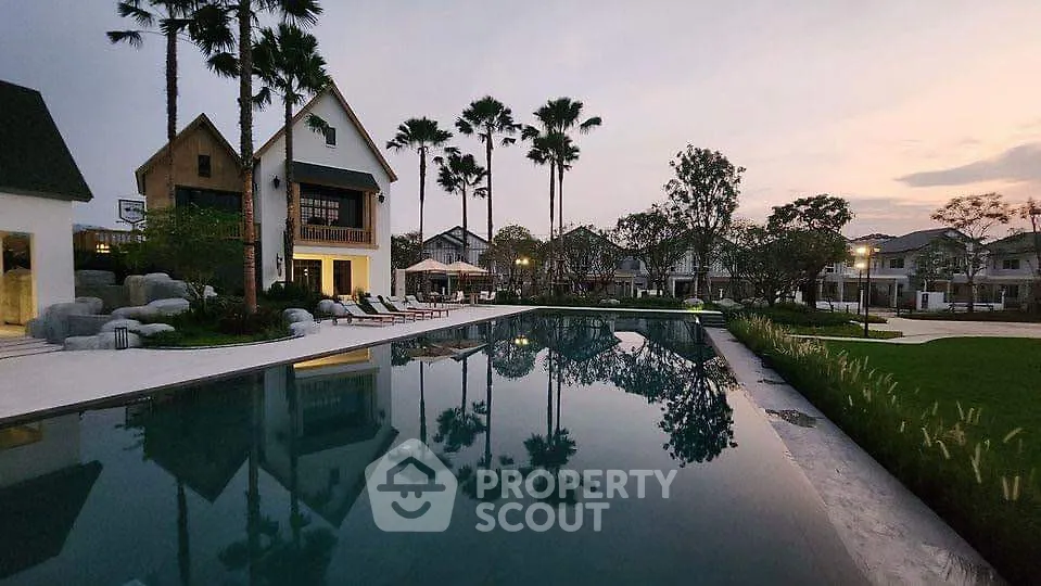 Luxurious residential pool area with elegant landscaping and modern architecture at sunset.