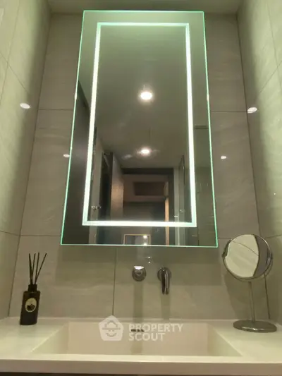 Modern bathroom with illuminated mirror and sleek sink design