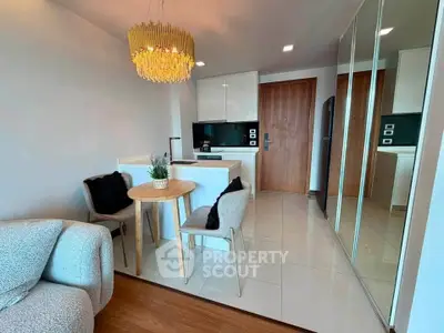 Modern open-plan living room with chic dining area and stylish kitchen in a cozy apartment.
