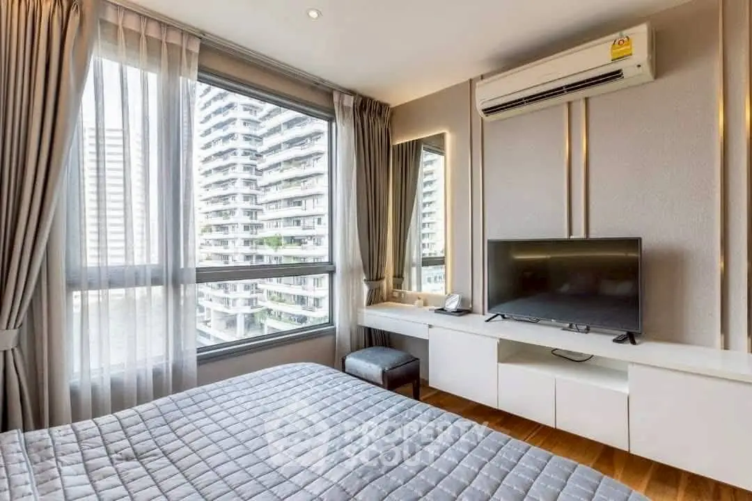 Modern bedroom with large window and city view, featuring air conditioning and sleek decor.