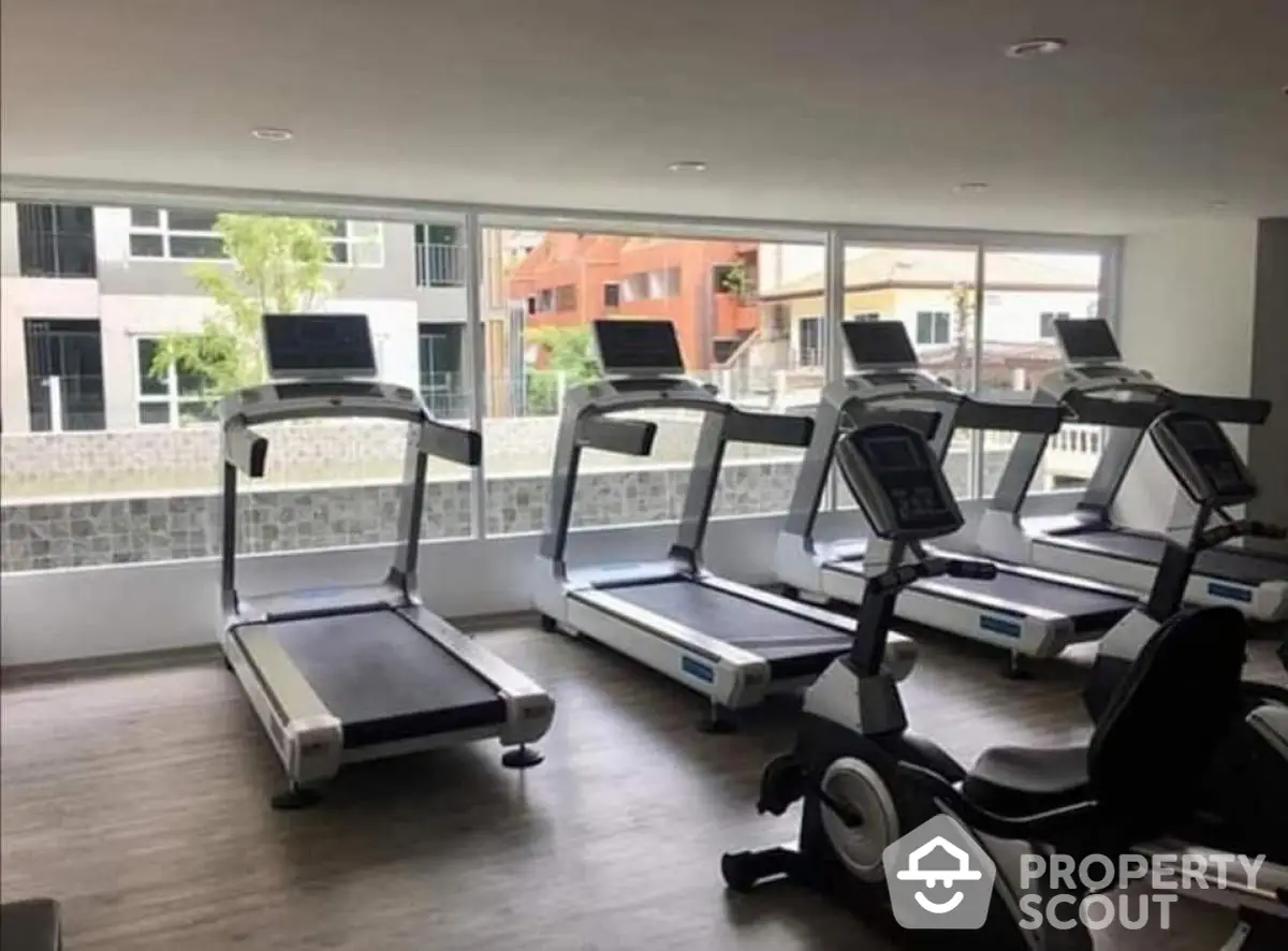 Modern gym with treadmills and exercise bike in residential building