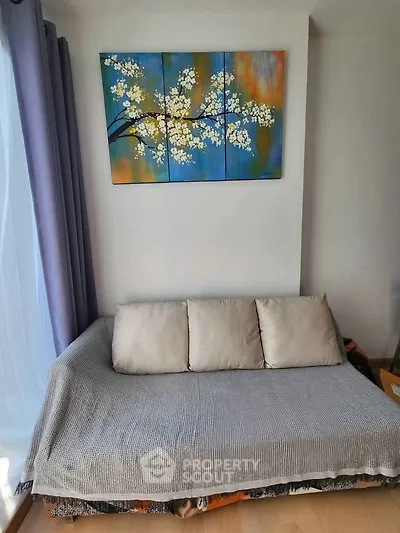 Cozy living room with stylish sofa and vibrant wall art, perfect for relaxation.