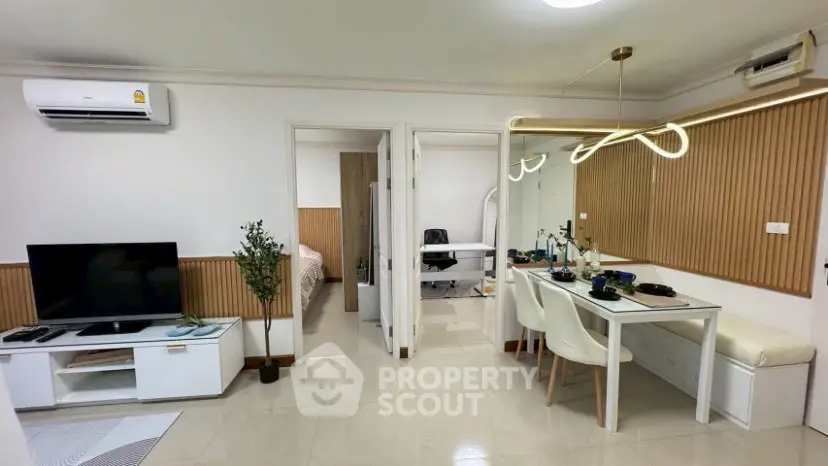 Modern living room with stylish decor and dining area in a cozy apartment.